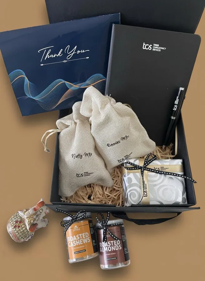 TCS guest hamper with a thank-you card, branded diary and pen, roasted nuts and a handcrafted elephant pair